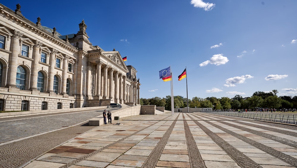 a large building with two flags in front of it