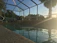 A bright, freshly installed pool enclosure glowing under a clear blue sky.