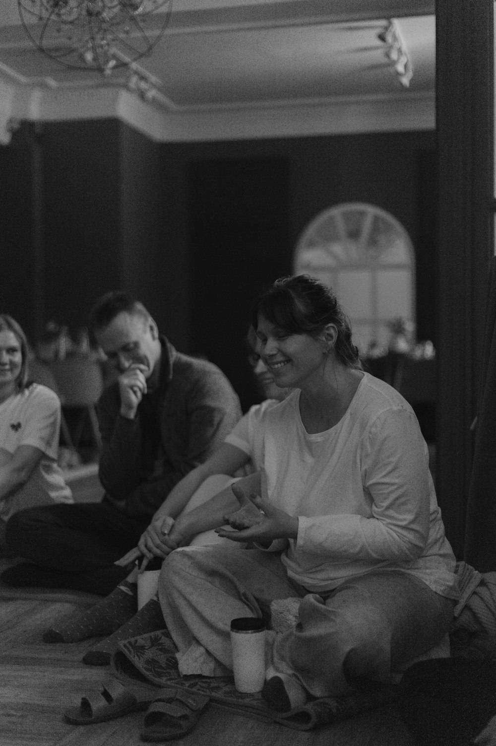 a black and white photo of a group of people sitting on the floor