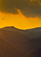 Sunset view over rolling hills covered in dense forest.