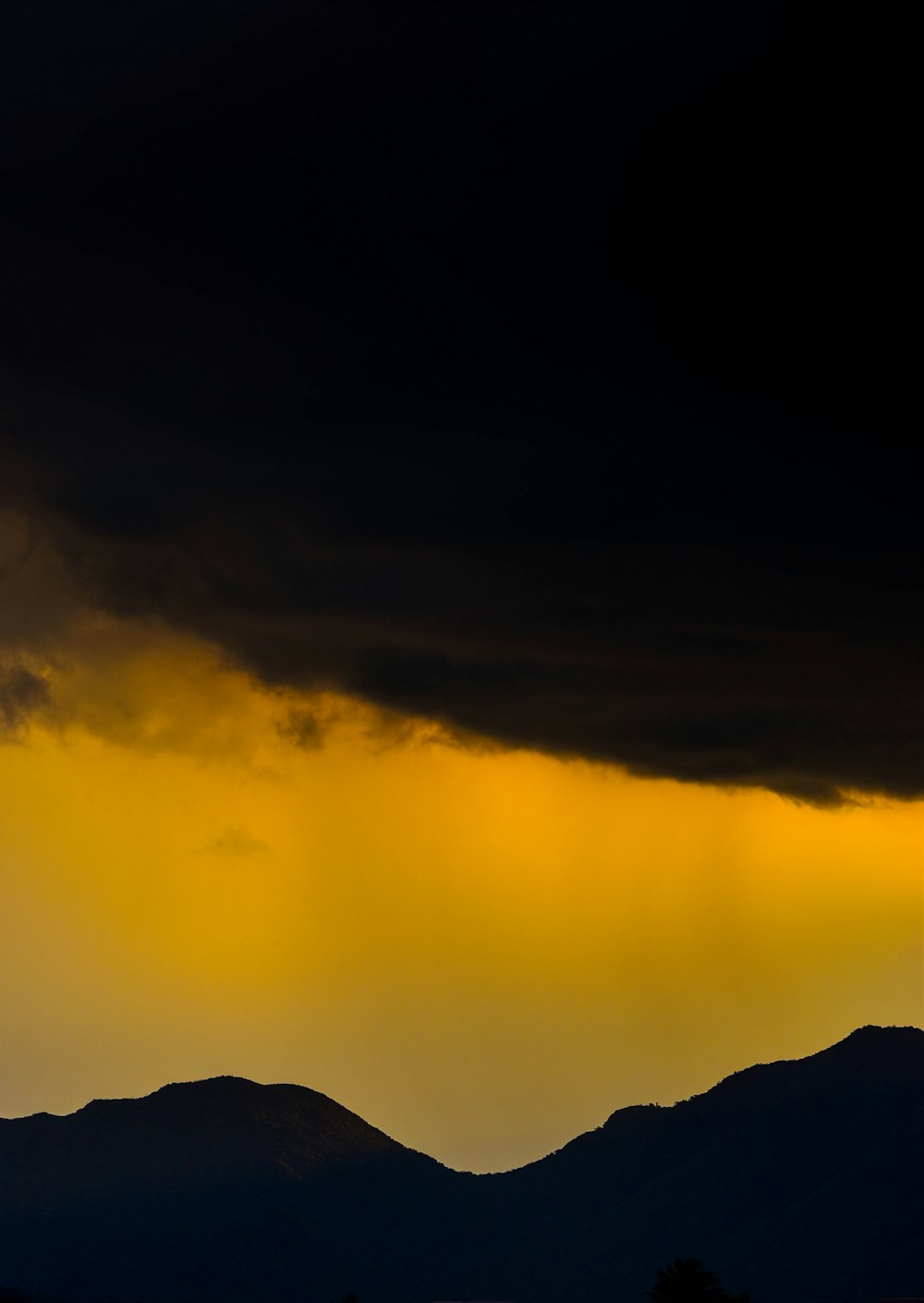 a plane flying in the sky with a dark cloud