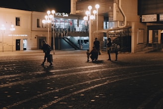 A late-night street scene outside a Brooklyn venue with people gathering under dim streetlights.