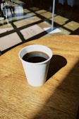 a cup of coffee sitting on top of a wooden table