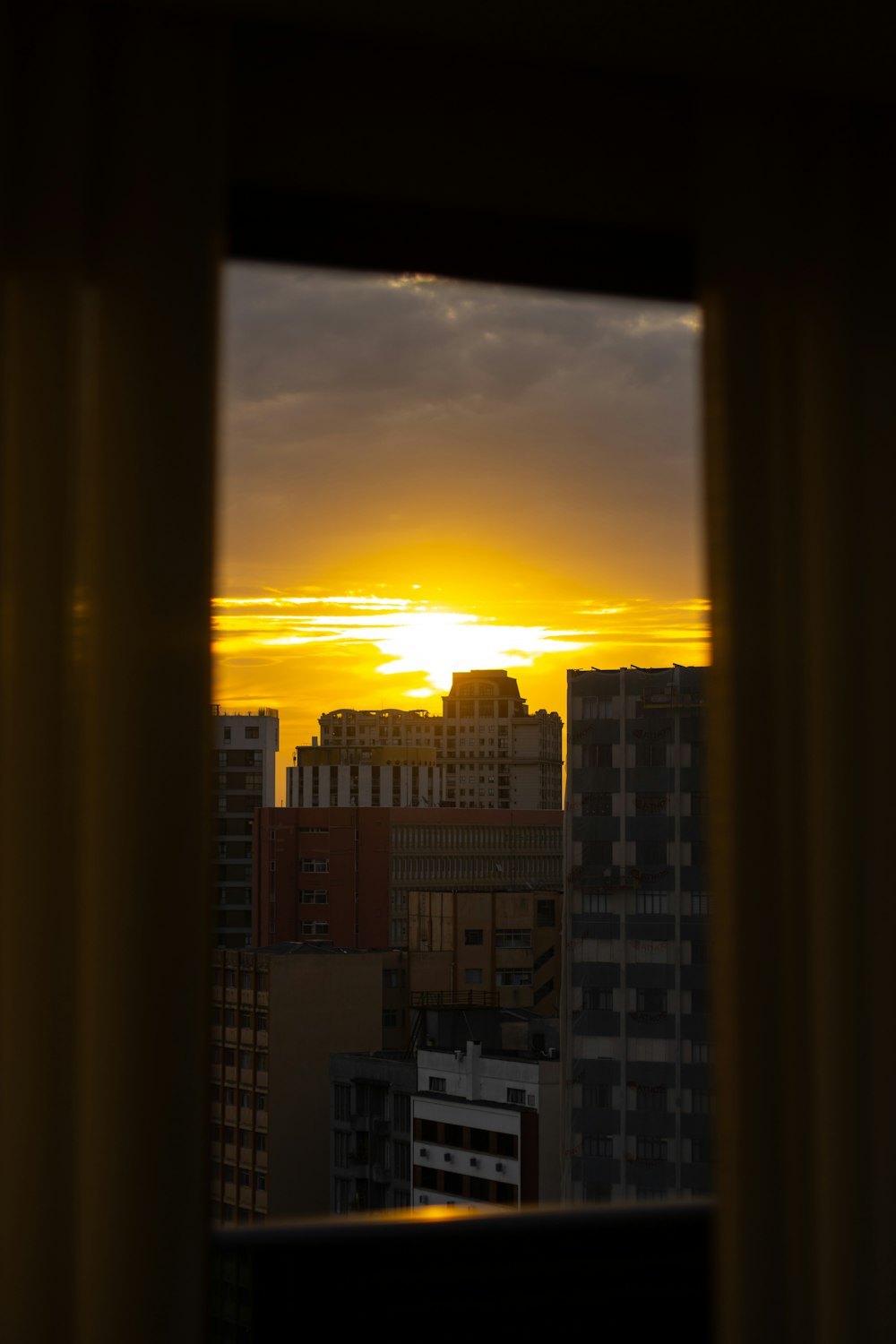 the sun is setting over a city with tall buildings