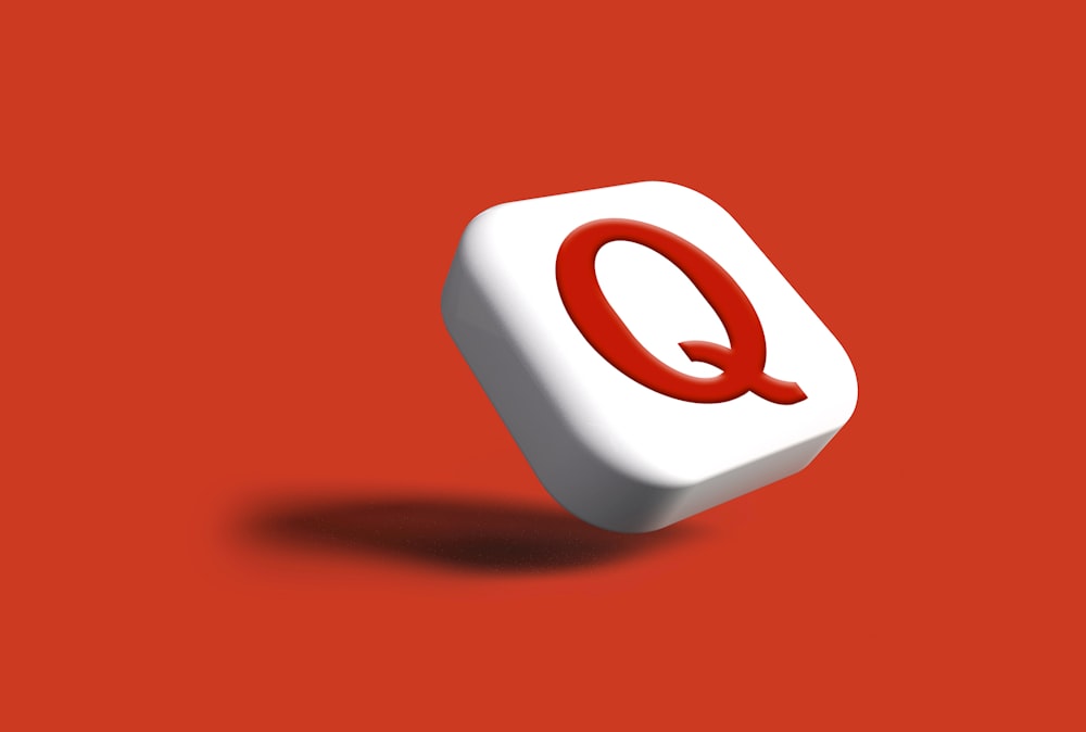 Ein weißes Objekt mit einem roten q darauf