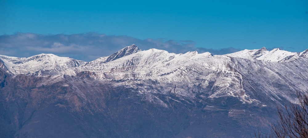 a snow covered mountain range under a blue sky