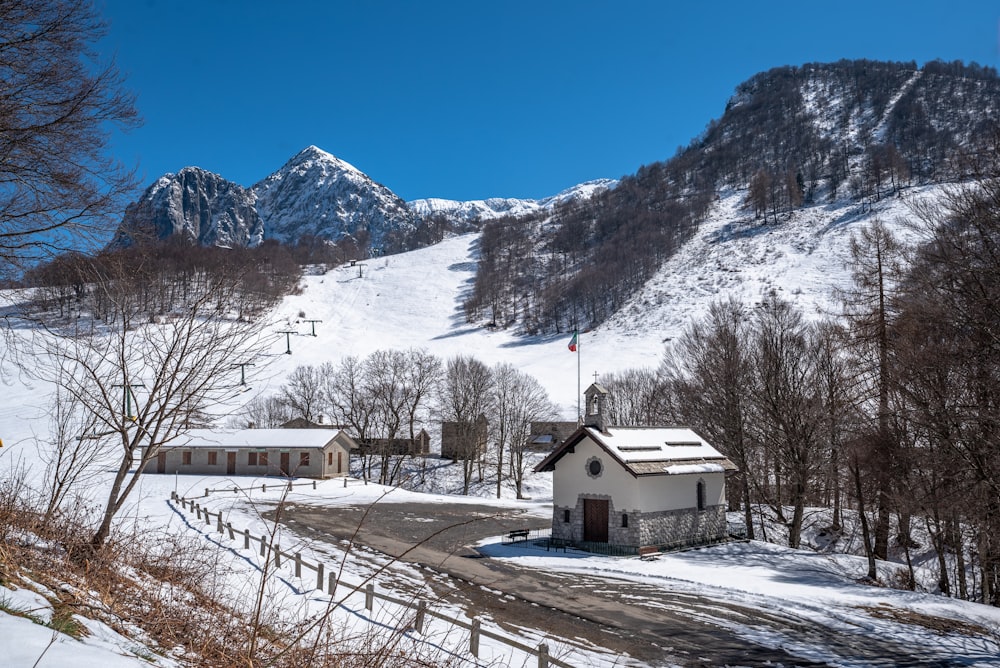 a snow covered mountain with a small white house in the foreground