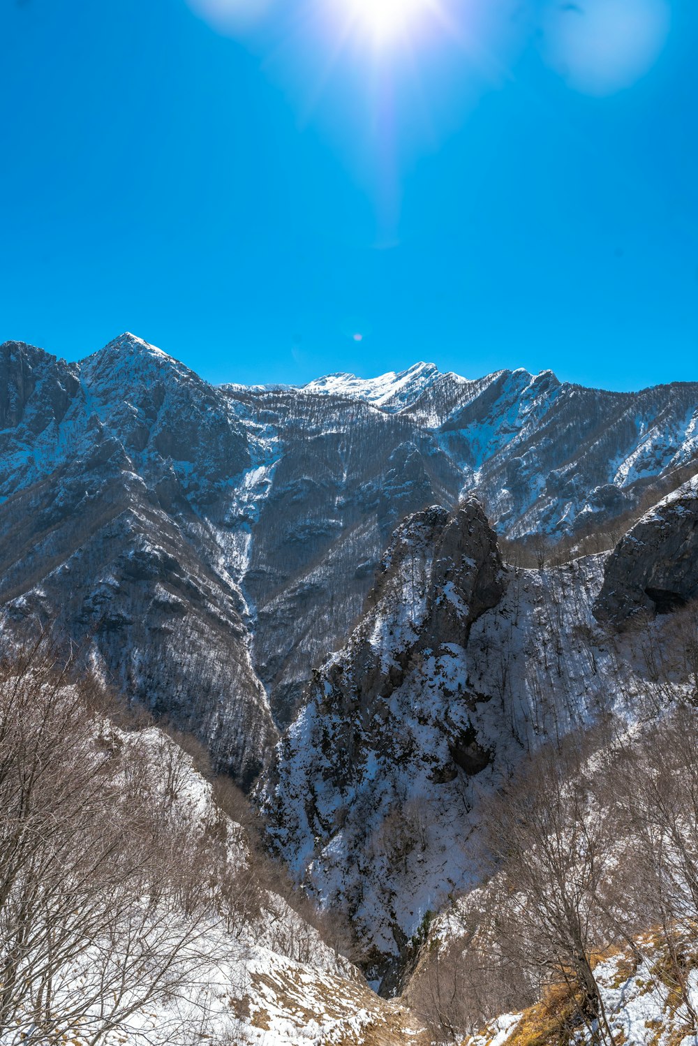 Die Sonne scheint hell über eine verschneite Bergkette