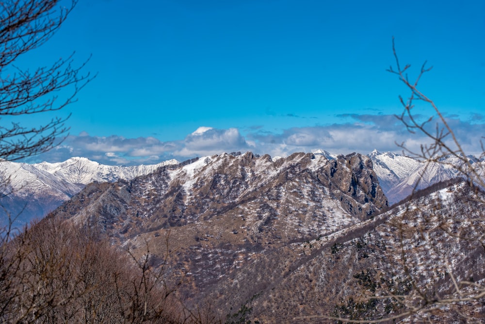 a view of a snowy mountain range from the top of a hill