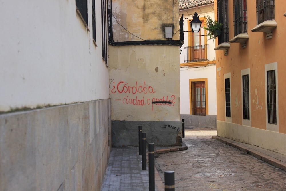 a narrow alley way with graffiti on the wall