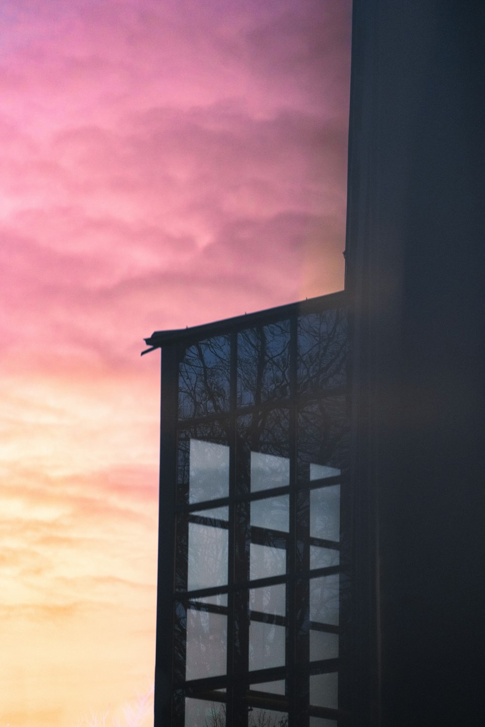 a view of a building with a pink sky in the background