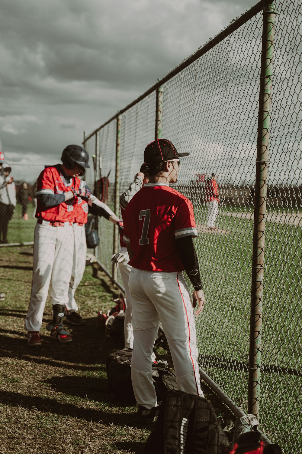 a baseball player holding a bat next to a fence