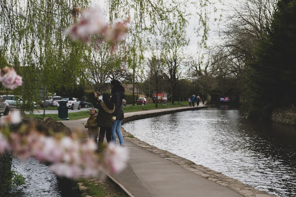 a couple of people standing next to a river