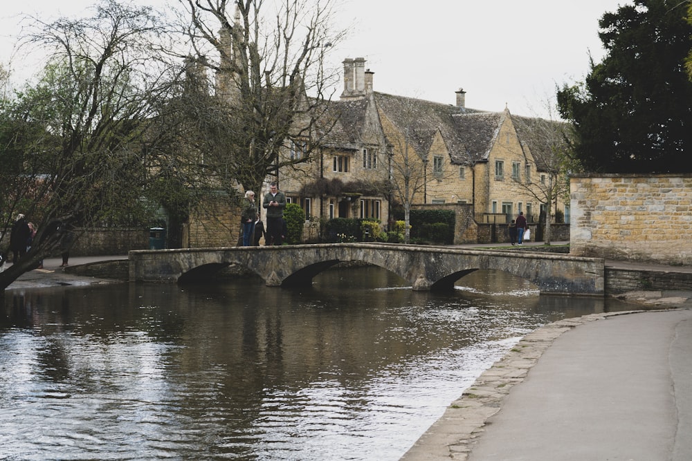 a bridge over a body of water in front of a house