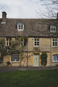 a stone building with a green door and windows