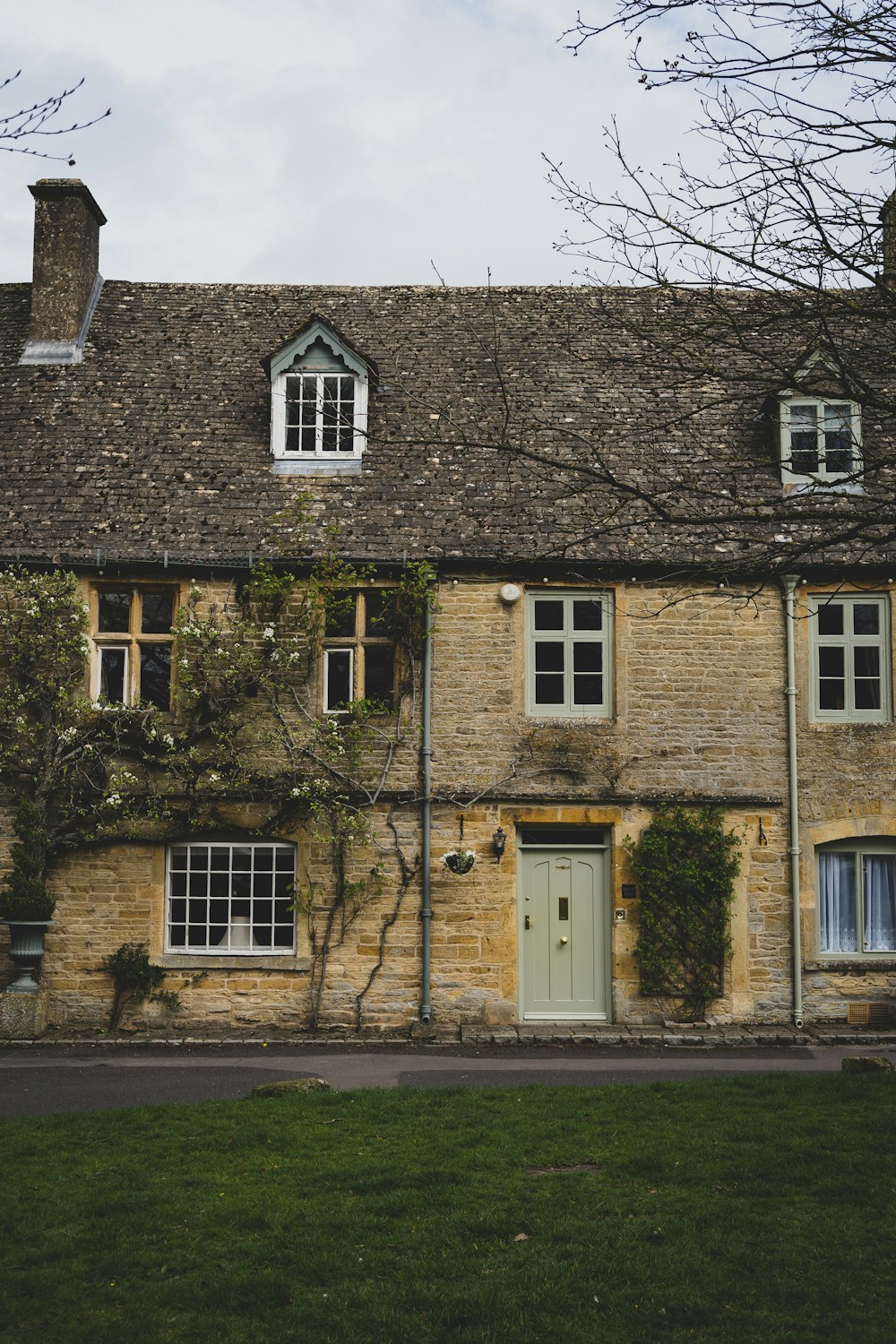 a stone building with a green door and windows