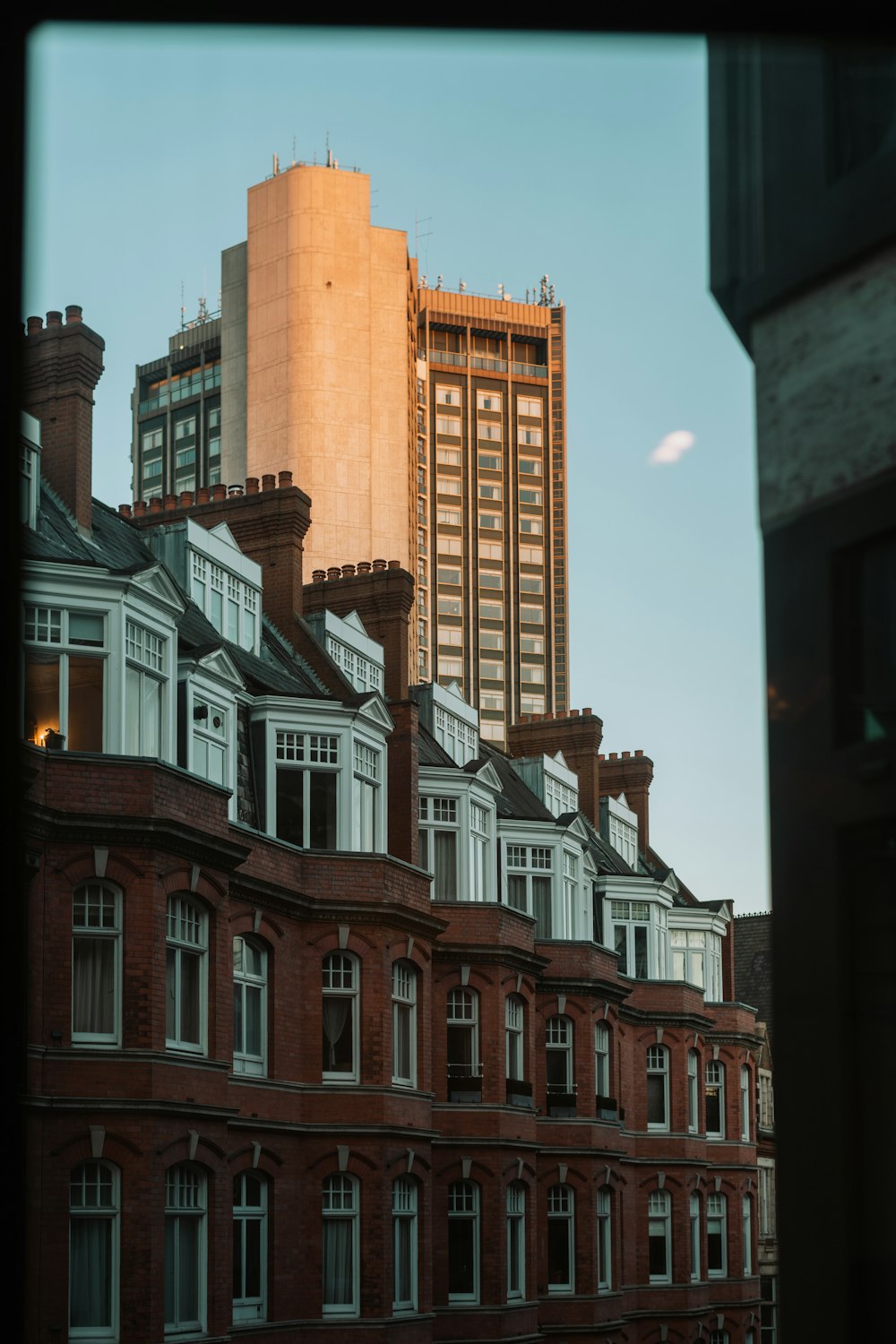 a row of red brick buildings with a tall building in the background