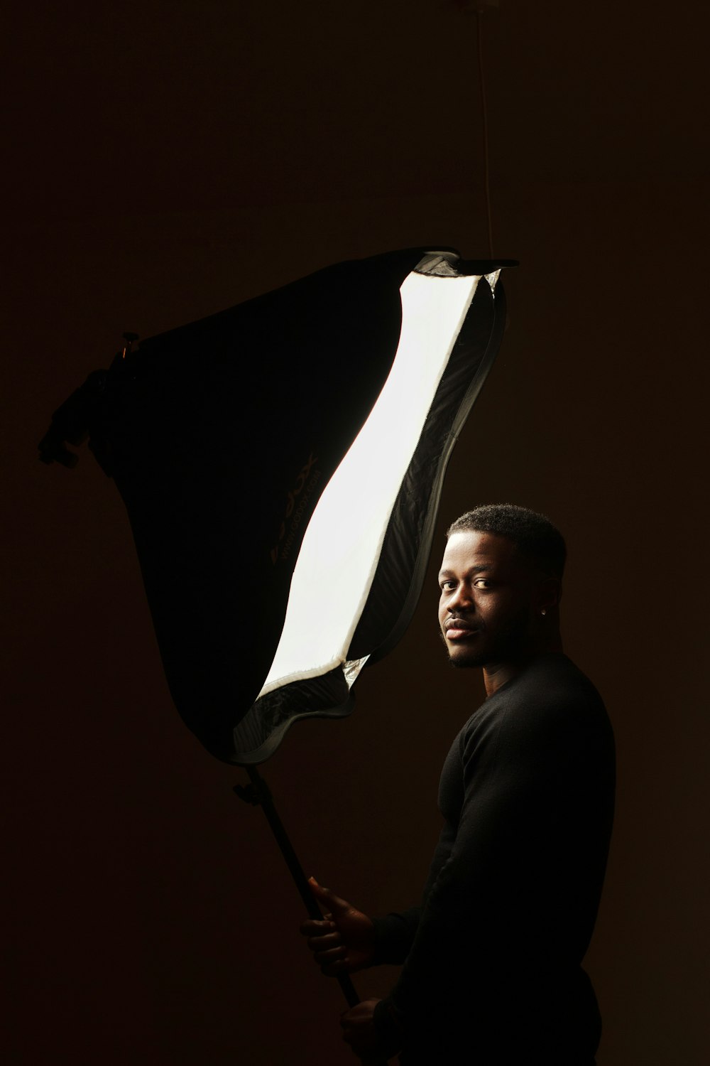 a man holding an umbrella in the dark