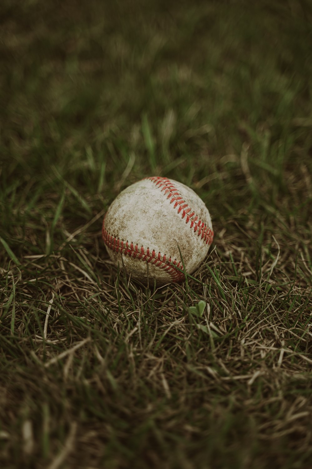 a baseball sitting on top of a lush green field