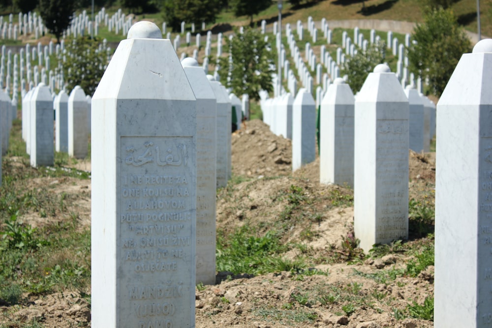 a bunch of white headstones in a field