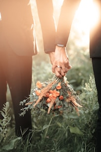 a couple of people holding a bouquet of flowers