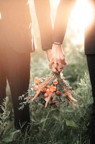 a couple of people holding a bouquet of flowers