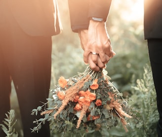 a couple of people holding a bouquet of flowers