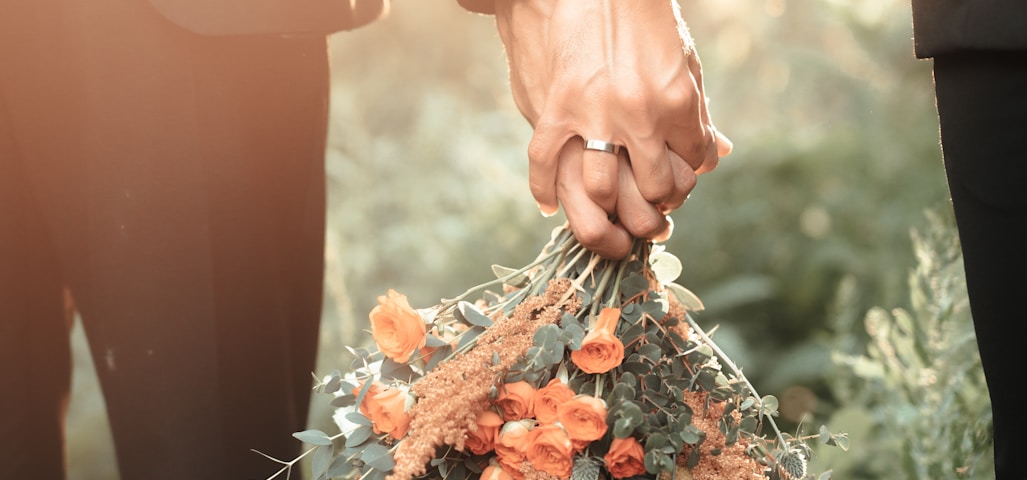 a couple of people holding a bouquet of flowers