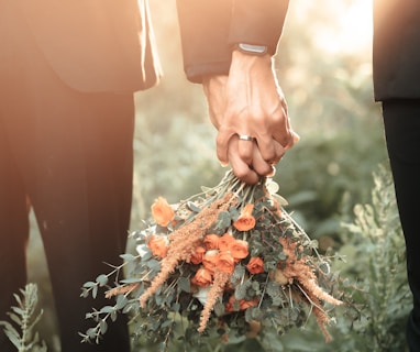 a couple of people holding a bouquet of flowers