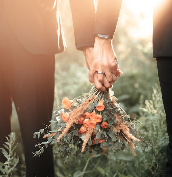 a couple of people holding a bouquet of flowers