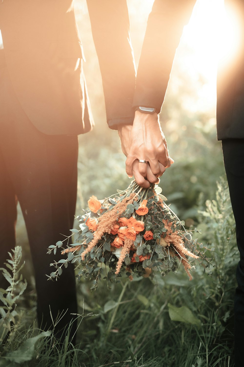 Un par de personas sosteniendo un ramo de flores