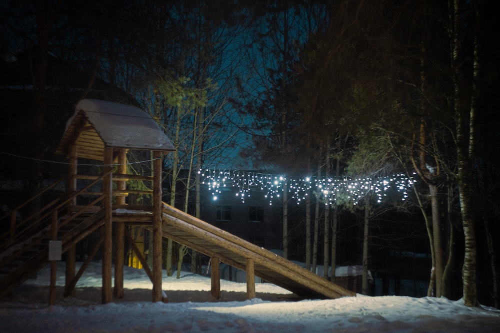 a wooden slide in the snow at night