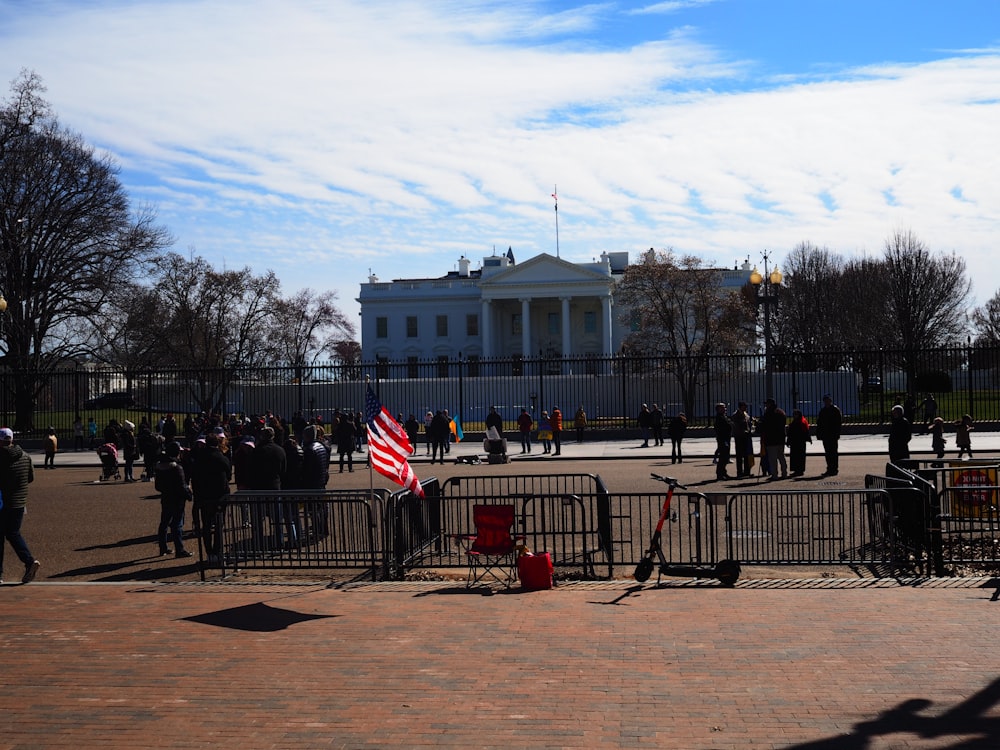 a group of people standing in front of a white house