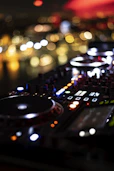 a close up of a dj controller with blurry lights in the background