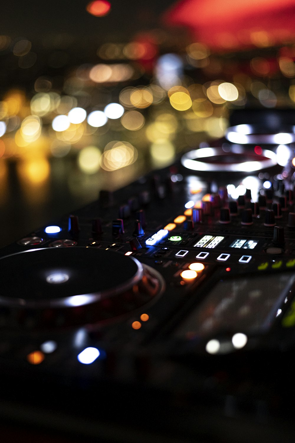 a close up of a dj controller with blurry lights in the background