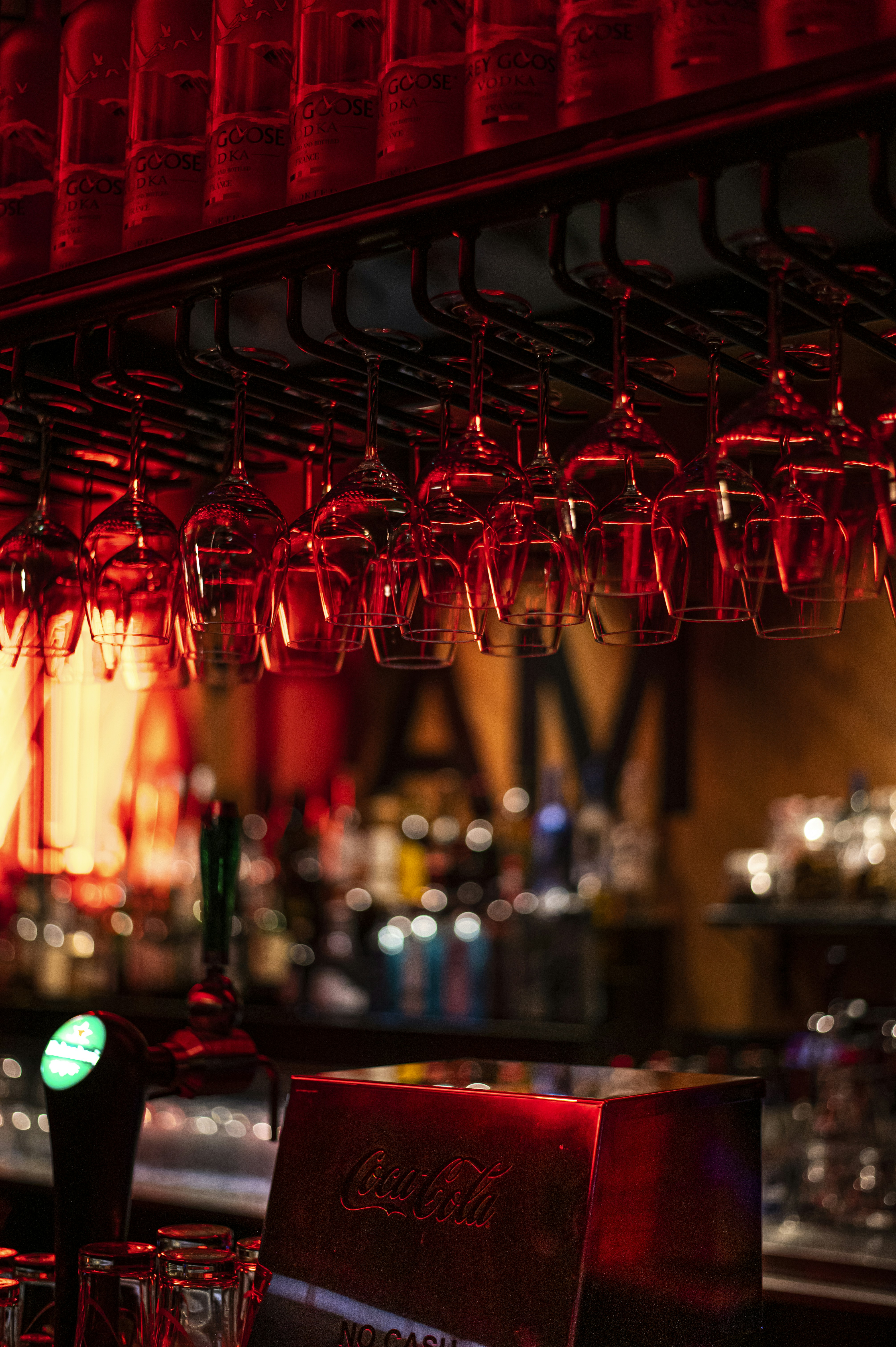 a bar with a lot of glasses hanging from the ceiling