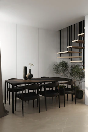 A sleek, modern wooden dining table with a smooth black finish, set against a dark backdrop.