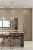 An elegant kitchen island with bar stools and utensils.