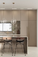 An elegant kitchen island with bar stools and pendant lights.