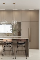A modern kitchen island with bar stools and sleek appliances in the background.
