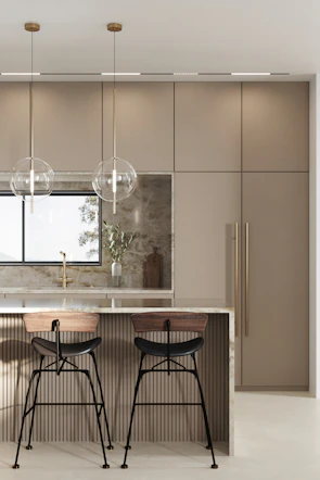 Kitchen island featuring a luxurious beige marble countertop illuminated by warm pendant lights.