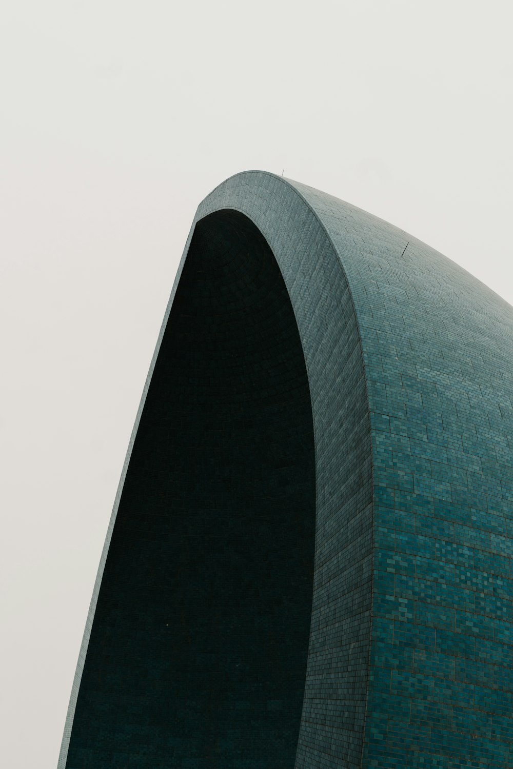 a tall building with a curved roof and a clock on it's side