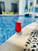 Close-up of a refreshing spa drink beside a sunlit poolside chair