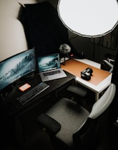 A friendly workspace with camera gear and a custom-built gaming PC on the desk.