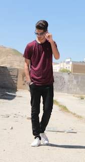 A young boy wearing trendy sunglasses outdoors on a sunny day.
