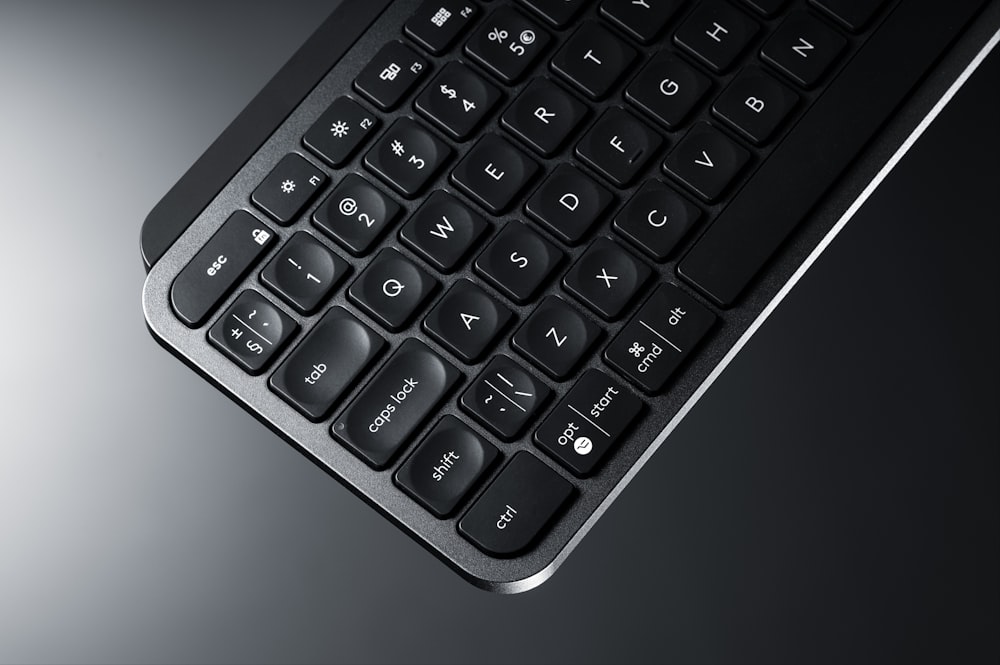 Un primer plano de un teclado negro sobre una mesa