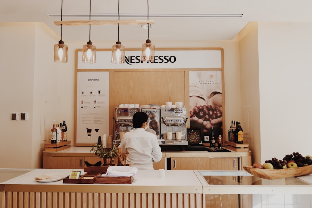 a person standing at a counter in a coffee shop