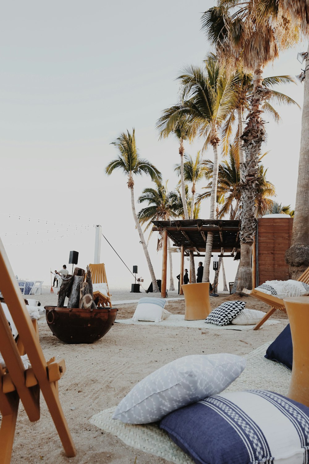 a beach scene with a chair and a hammock