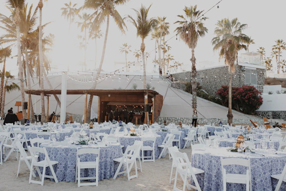 A charming rustic event setup at Finca San Juan with string lights and wooden tables.