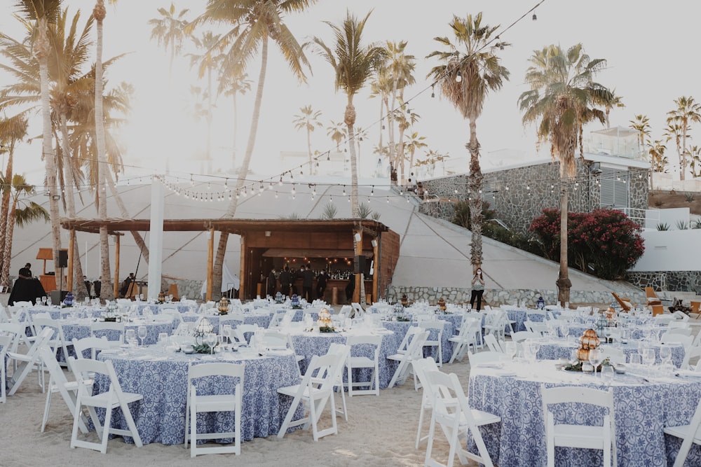 a wedding reception set up with blue and white tables and chairs